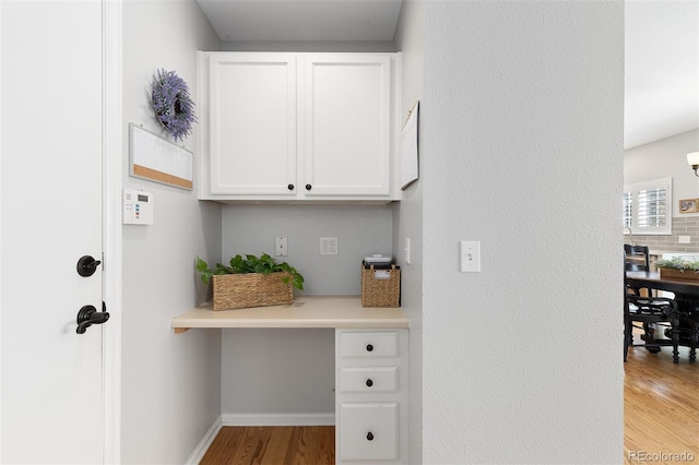 interior space featuring light wood-type flooring and baseboards