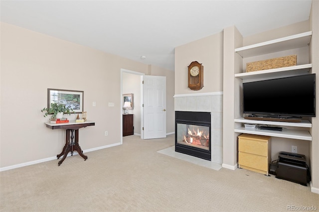 living room with light carpet, a tiled fireplace, and baseboards