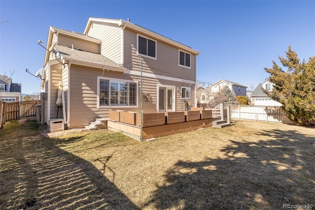 rear view of house featuring a fenced backyard, a lawn, and a wooden deck