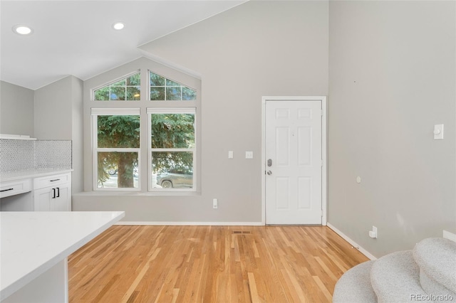 interior space featuring lofted ceiling and light wood-type flooring