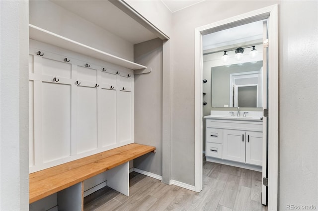 mudroom with sink and light hardwood / wood-style flooring