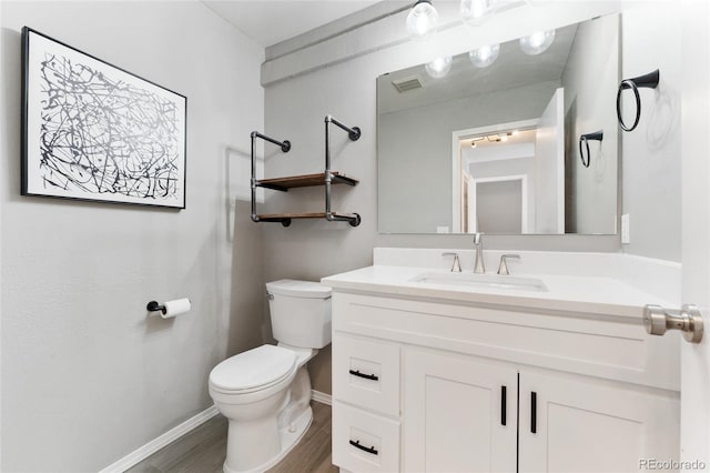 bathroom with vanity, hardwood / wood-style floors, and toilet