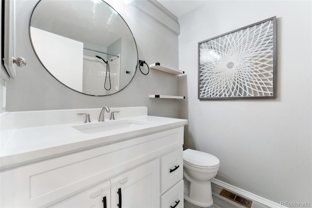 bathroom featuring vanity, a shower, and toilet