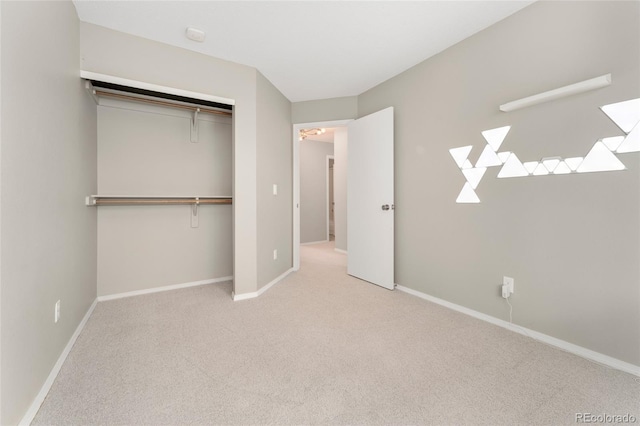 unfurnished bedroom featuring light carpet and a closet