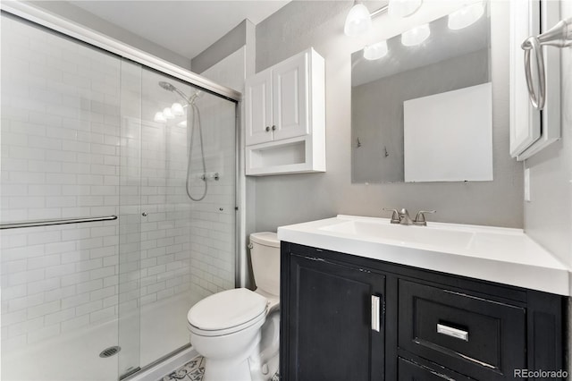 bathroom featuring vanity, toilet, and an enclosed shower