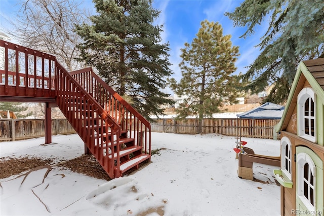 yard covered in snow with a wooden deck