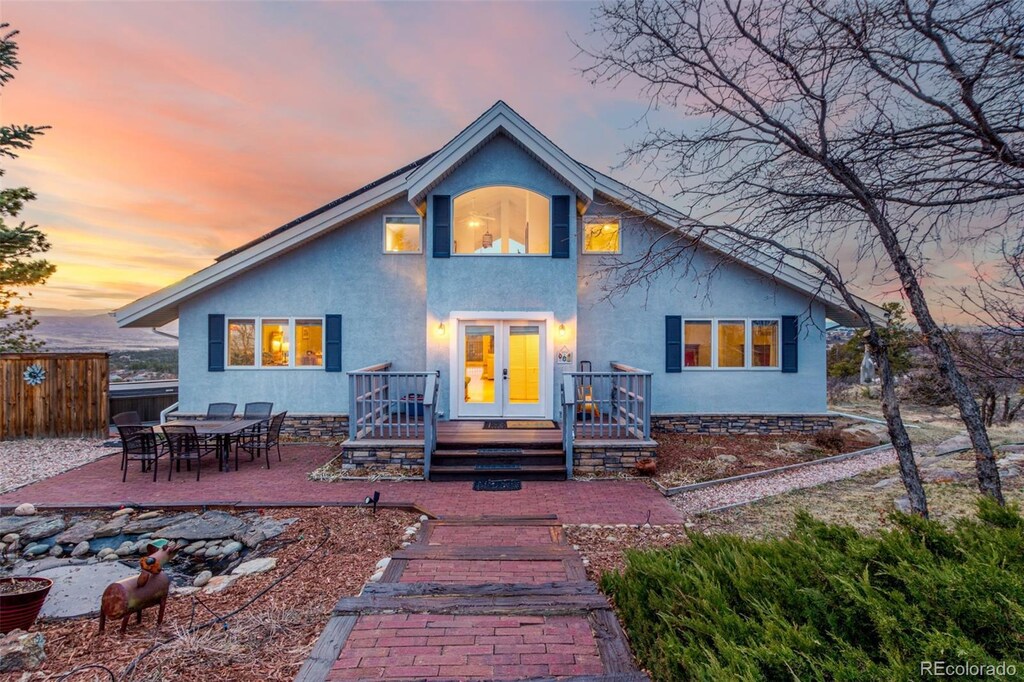 5271 N Mesa Dr, Castle Rock, CO 80108 - back of house at dusk featuring stucco siding, fence, french doors, and a patio