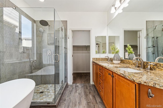 full bath featuring a sink, wood finished floors, and a stall shower