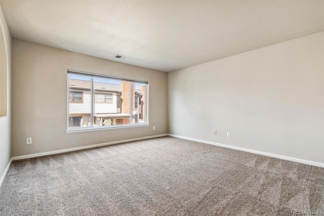 carpeted empty room with visible vents, baseboards, and a textured ceiling