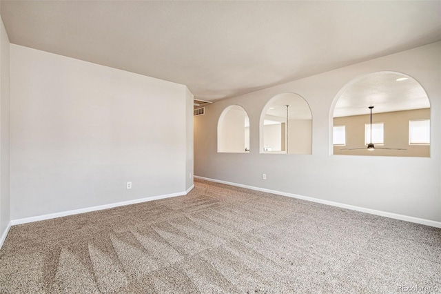 unfurnished room with visible vents, baseboards, and carpet floors