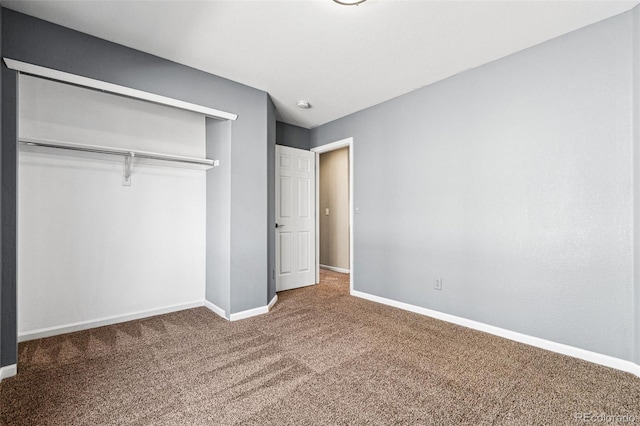 unfurnished bedroom featuring a closet, baseboards, and carpet flooring