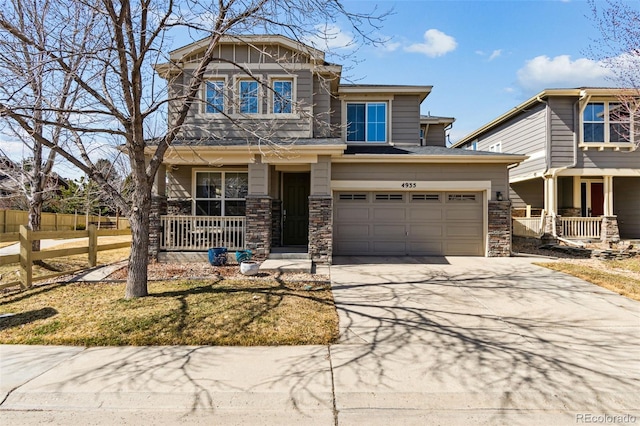 craftsman house with concrete driveway, an attached garage, covered porch, and stone siding