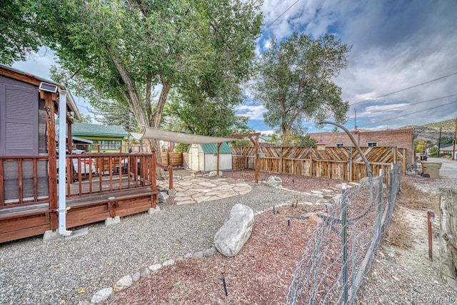 view of yard featuring a storage shed and a wooden deck