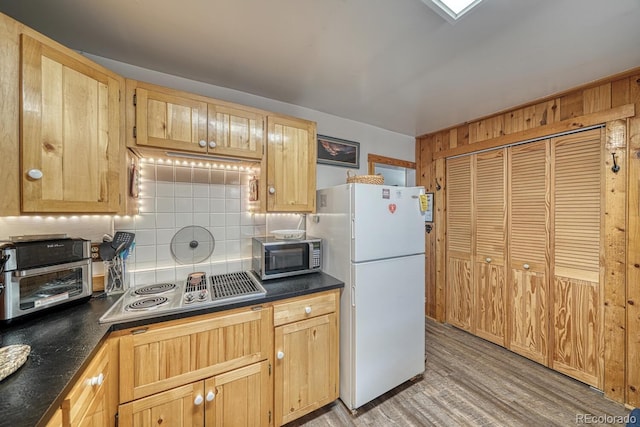 kitchen with stainless steel appliances, light hardwood / wood-style floors, decorative backsplash, and light brown cabinets