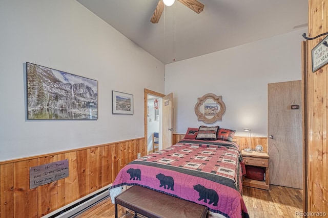 bedroom with high vaulted ceiling, wooden walls, ceiling fan, wood-type flooring, and baseboard heating