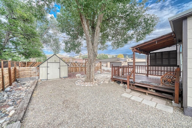 view of yard featuring a shed, a patio, a sunroom, and a wooden deck