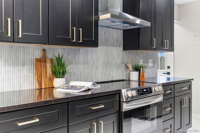 1310 E Amherst Ave, Englewood, CO 80113 - kitchen with wall chimney exhaust hood, stainless steel electric stove, tasteful backsplash, and dark countertops