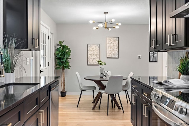 1310 E Amherst Ave, Englewood, CO 80113 - kitchen featuring stainless steel appliances, ventilation hood, light wood finished floors, and a chandelier