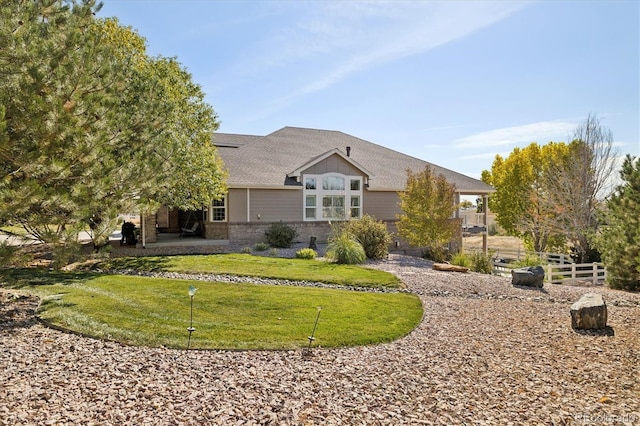 10044 E 146th Pl, Brighton, CO 80602 - back of house with a yard, brick siding, fence, and a shingled roof