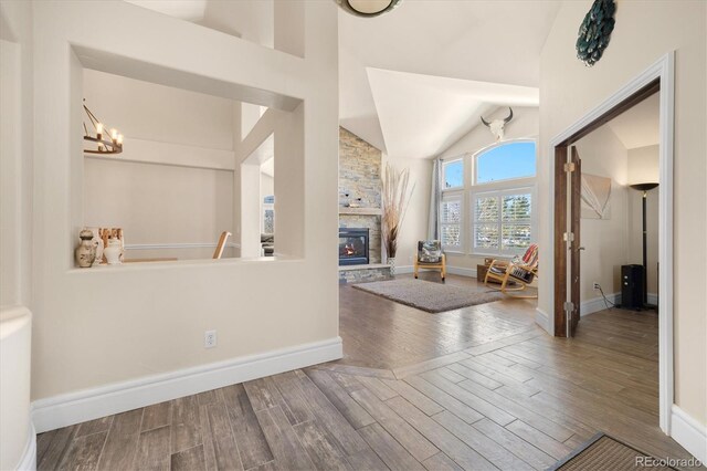 10044 E 146th Pl, Brighton, CO 80602 - entrance foyer featuring a fireplace, wood finished floors, baseboards, a notable chandelier, and lofted ceiling