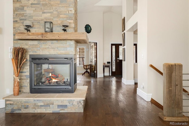 10044 E 146th Pl, Brighton, CO 80602 - unfurnished living room featuring wood-type flooring, baseboards, vaulted ceiling, and a stone fireplace