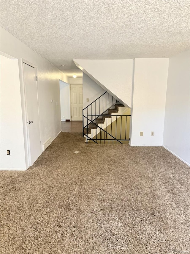 carpeted empty room with a textured ceiling