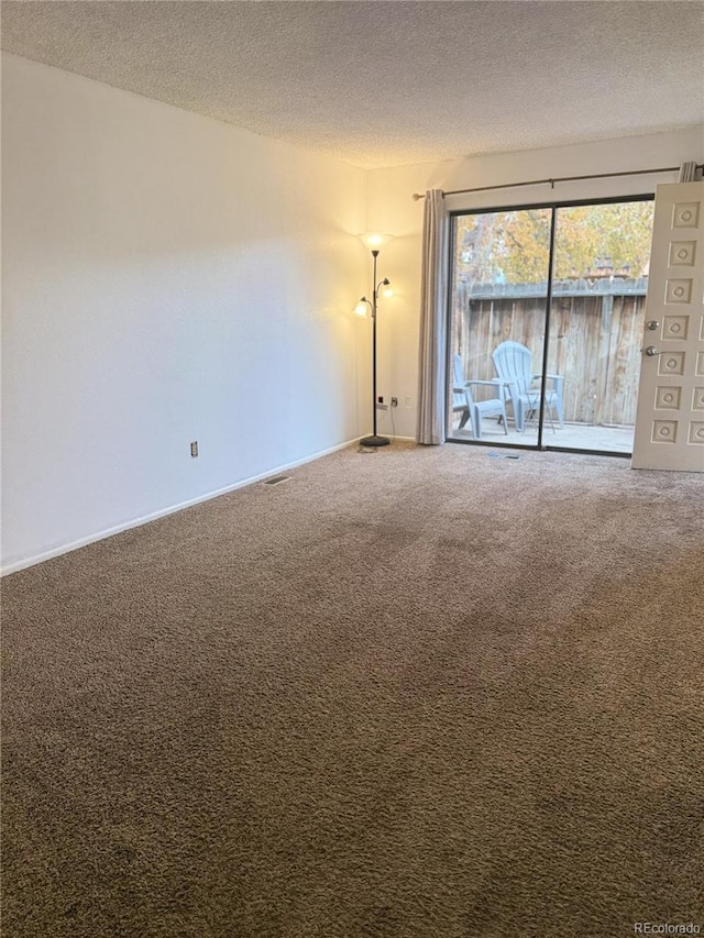 empty room with carpet and a textured ceiling