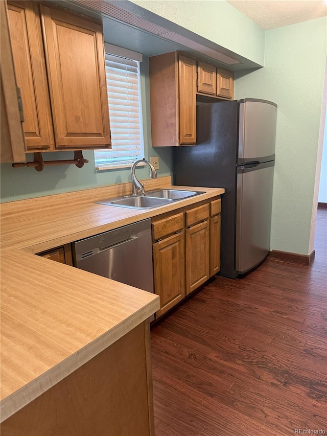 kitchen with butcher block countertops, sink, stainless steel appliances, and dark hardwood / wood-style floors