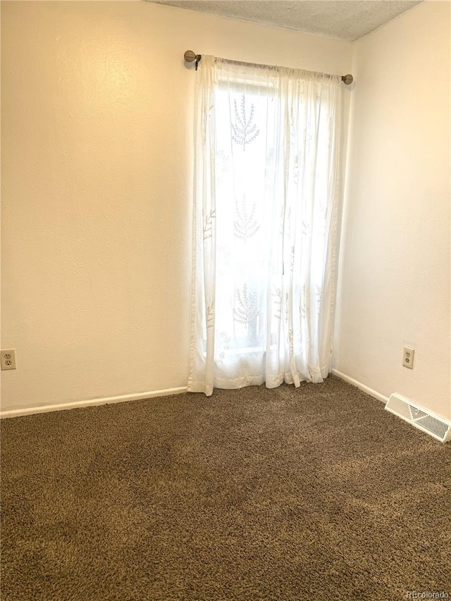 unfurnished room featuring carpet flooring and a textured ceiling