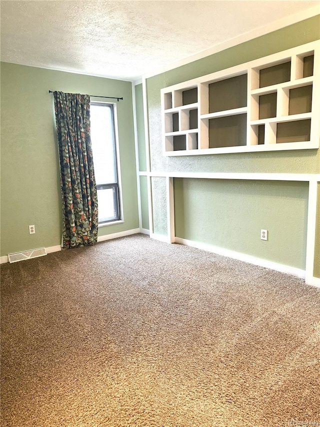 unfurnished room featuring carpet flooring and a textured ceiling