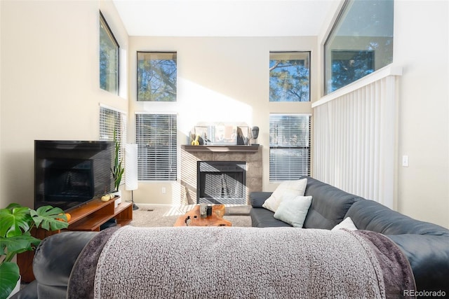 carpeted living room featuring a towering ceiling and a healthy amount of sunlight