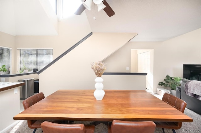 carpeted dining space with ceiling fan