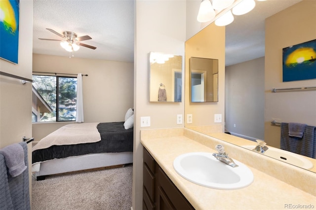 bathroom featuring ceiling fan, vanity, and a textured ceiling