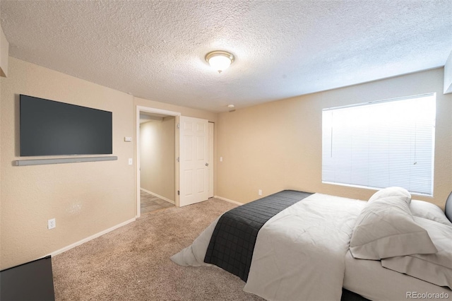 bedroom featuring light carpet and a textured ceiling