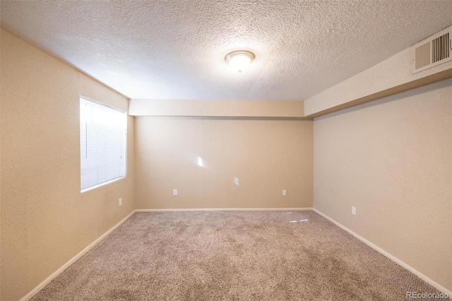 unfurnished room with carpet and a textured ceiling