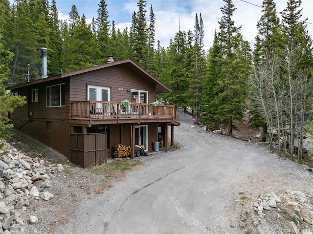 159 Lake Rd, Idaho Springs, CO 80452 - view of front facade with a wooden deck, french doors, driveway, and a wooded view