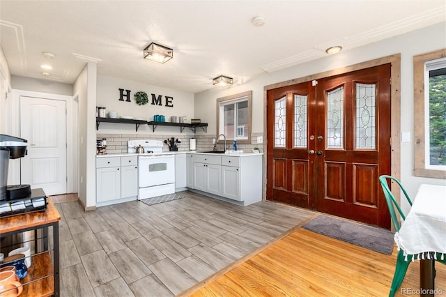 159 Lake Rd, Idaho Springs, CO 80452 - kitchen with white range with electric cooktop, open shelves, a sink, light countertops, and light wood-style flooring
