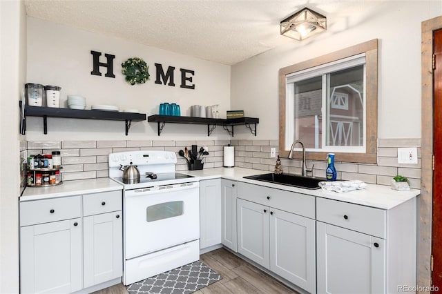 159 Lake Rd, Idaho Springs, CO 80452 - kitchen with white electric range oven, open shelves, a sink, light countertops, and decorative backsplash
