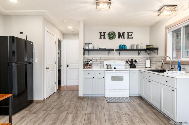 159 Lake Rd, Idaho Springs, CO 80452 - kitchen featuring freestanding refrigerator, white range with electric cooktop, open shelves, a sink, and light wood-type flooring