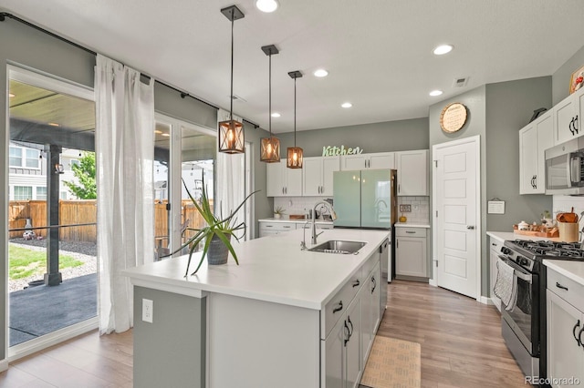 27893 E 6th Pl, Aurora, CO 80018 - kitchen featuring stainless steel appliances, a sink, light countertops, tasteful backsplash, and recessed lighting