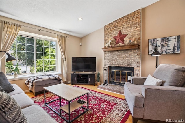 19061 E Oxford Dr, Aurora, CO 80013 - living area with lofted ceiling, wood finished floors, and a fireplace