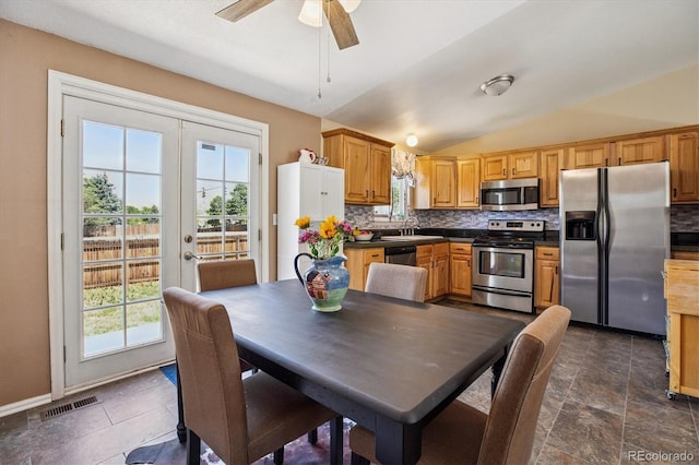 19061 E Oxford Dr, Aurora, CO 80013 - kitchen featuring stainless steel appliances, decorative backsplash, lofted ceiling, dark countertops, and a ceiling fan