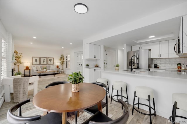 dining room featuring light wood finished floors and recessed lighting