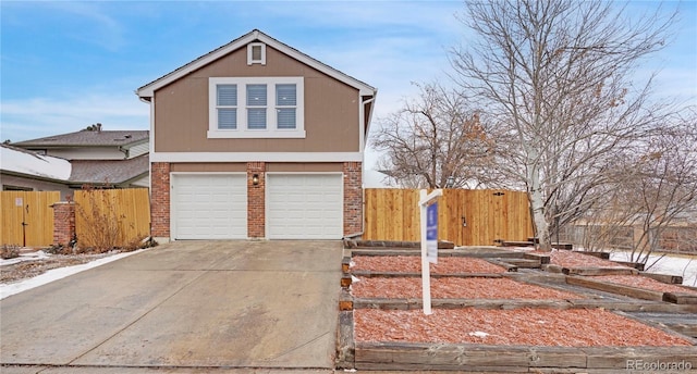 view of front of house featuring brick siding, an attached garage, concrete driveway, and fence