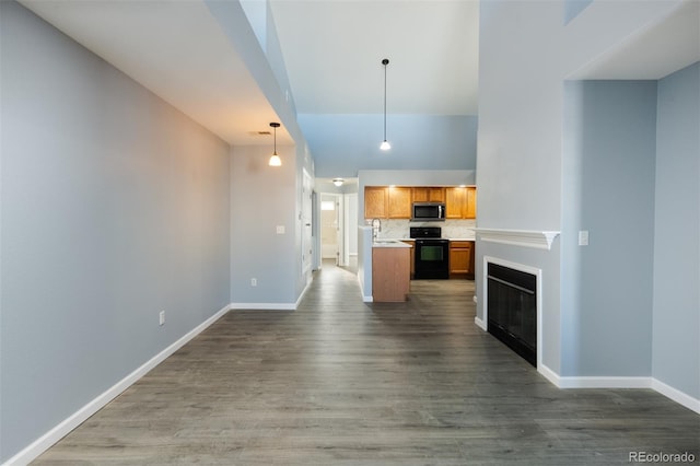 kitchen featuring electric range, sink, tasteful backsplash, dark hardwood / wood-style flooring, and pendant lighting