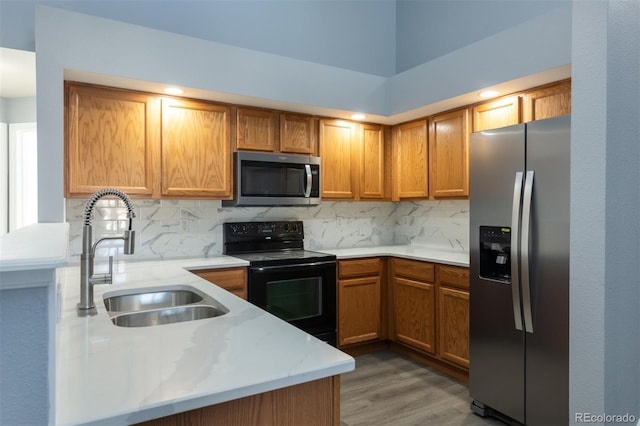 kitchen featuring decorative backsplash, appliances with stainless steel finishes, light stone countertops, sink, and dark hardwood / wood-style floors