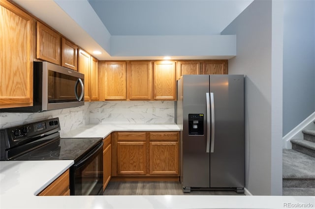 kitchen with hardwood / wood-style floors, stainless steel appliances, and tasteful backsplash