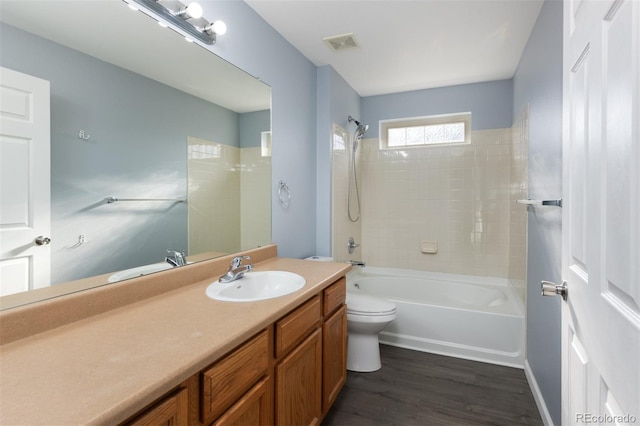 full bathroom featuring toilet, vanity, tiled shower / bath combo, and hardwood / wood-style flooring