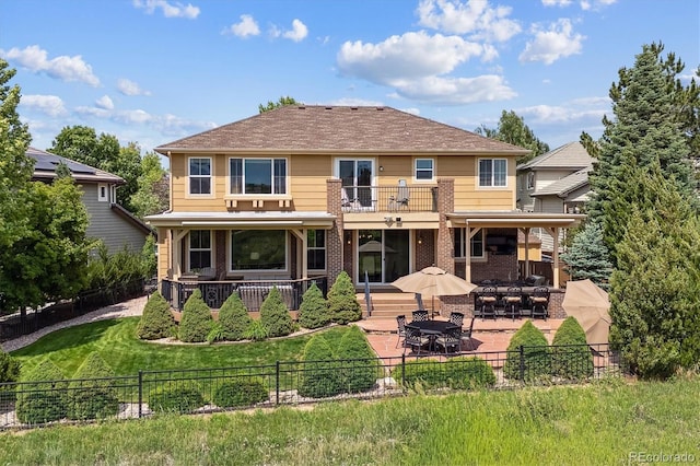 10258 Pennington Ln, Highlands Ranch, CO 80126 - back of property featuring a balcony, a fenced backyard, a patio, and brick siding