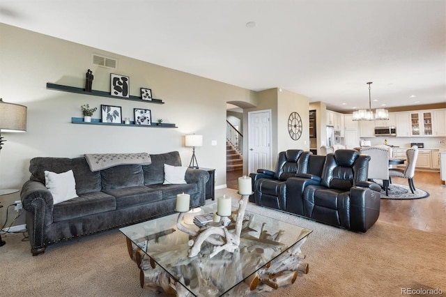 10258 Pennington Ln, Highlands Ranch, CO 80126 - living room featuring arched walkways, light carpet, a chandelier, stairs, and recessed lighting